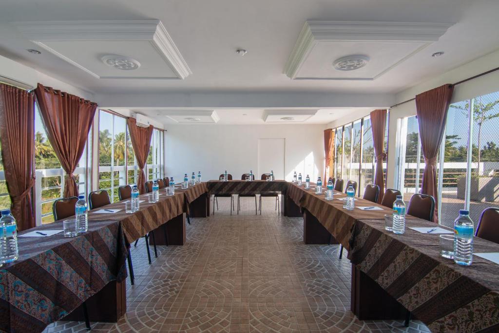 een grote kamer met lange tafels, stoelen en ramen bij Diva Lombok Resort in Senggigi 