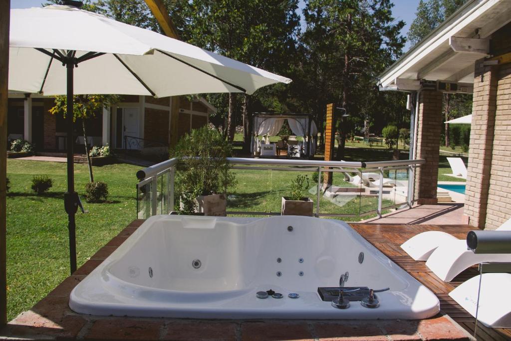 bañera en un patio con sombrilla en Al Rio Suites en Nono