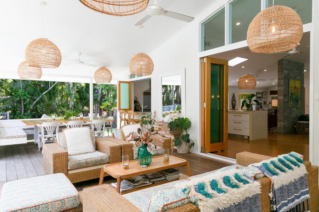 ein Wohnzimmer mit Sofas und einem Tisch in der Unterkunft Pineapple Petes Beach House in Port Douglas