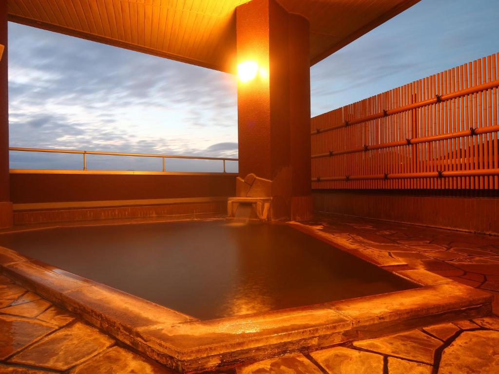 a hot tub on the roof of a building at Hotel Omodaka in Yamanouchi