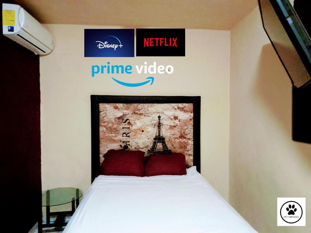a bed with red pillows and a sign for prime video at Relax Home Aeropuerto-Tren Maya in Chetumal