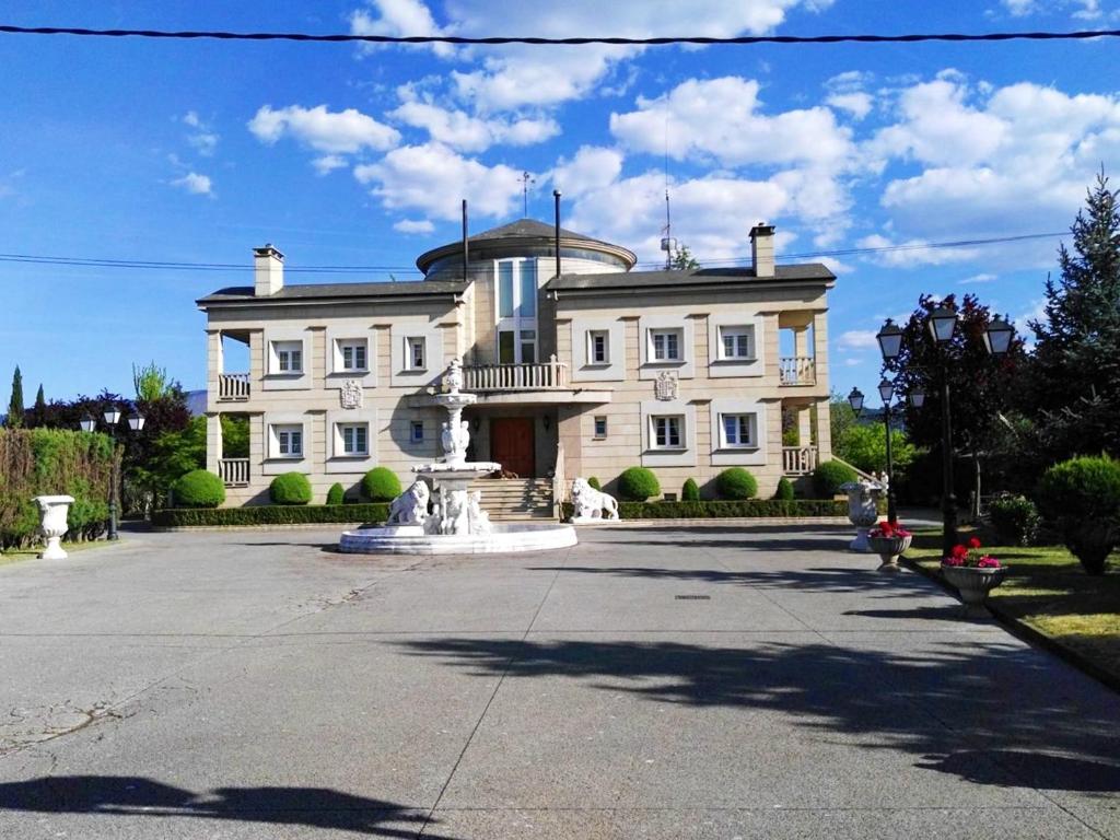 a large house with a fountain in front of it at Spacious house with pool and garden in Congosto in Congosto