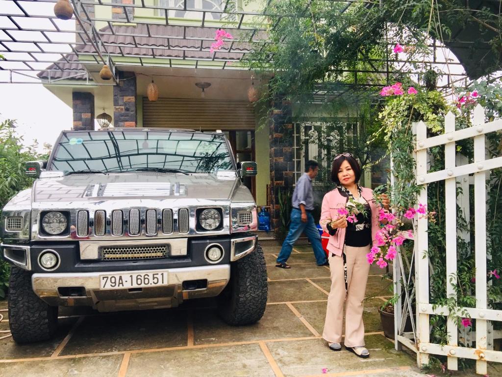 a woman standing next to a jeep outside a house at Moka House in Da Lat