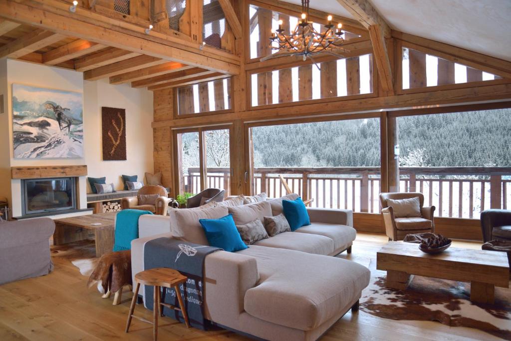 a living room with couches and a fireplace in a house at Chalet Cannelle in Châtel