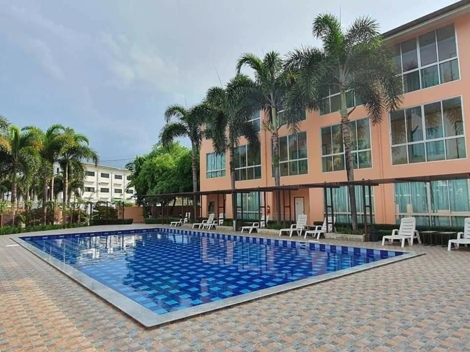 a large swimming pool in front of a building at The Victory Hotel in Ban Muang Daeng