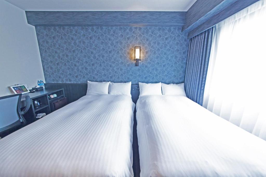Postel nebo postele na pokoji v ubytování FP HOTELS South-Namba