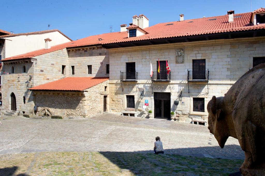 a person standing in front of a building at Parador de Santillana Gil Blas in Santillana del Mar