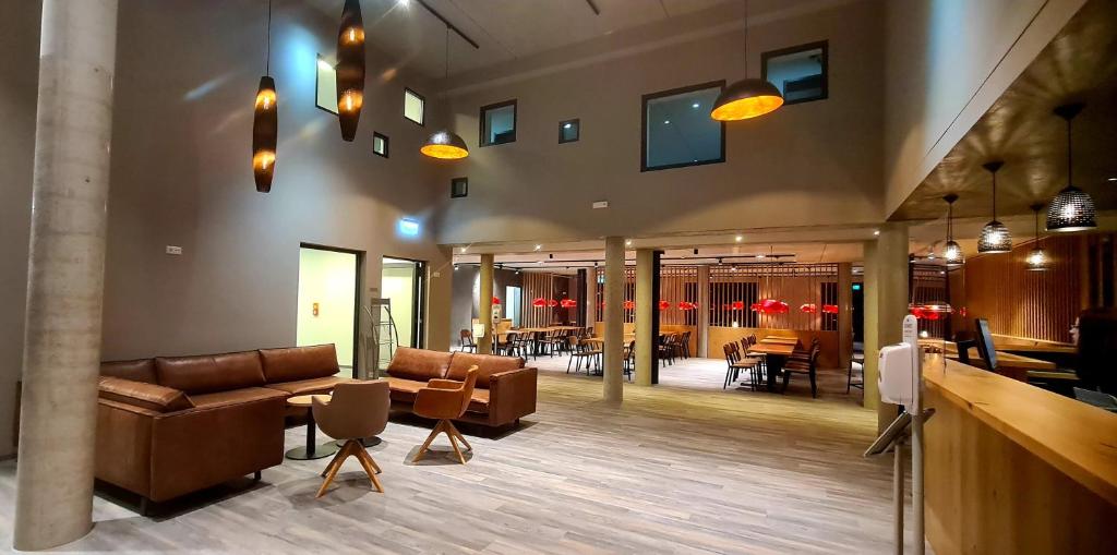 eine Lobby mit Sofas und Tischen sowie ein Restaurant in der Unterkunft Euro Hotel Wertheim in Wertheim
