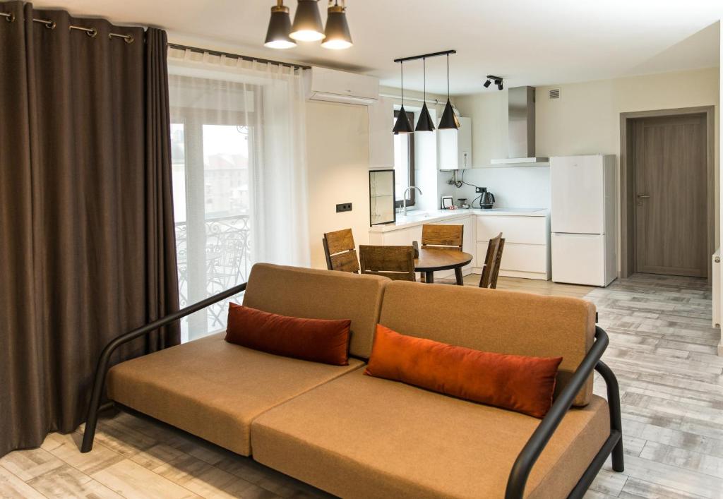 Elite Loft Apart في كولوميا: غرفة معيشة مع أريكة ومطبخ
