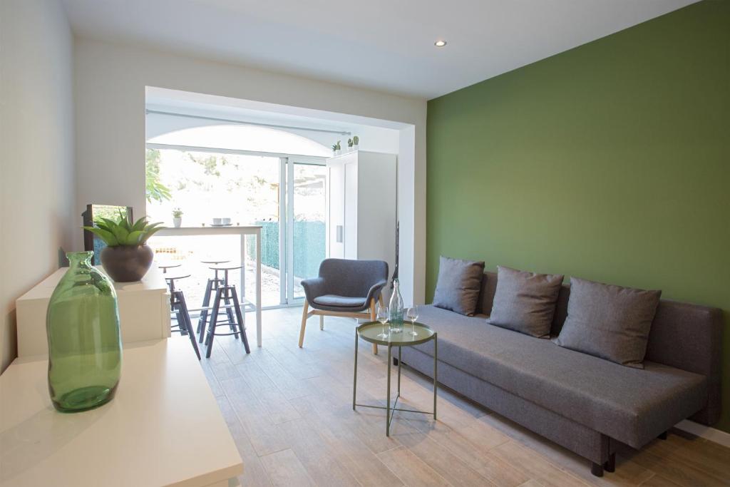 een woonkamer met een bank en een tafel bij Joli studio avec jardin bord de mer in Saint-Mandrier-sur-Mer