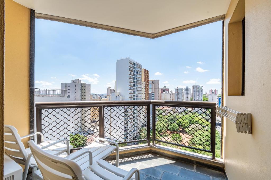 a balcony with chairs and a view of a city at Park Tower Campinas Residence by Nacional Inn in Campinas