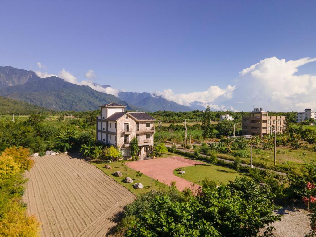 an aerial view of a building with mountains in the background at Floral Land B&B in Zhixue