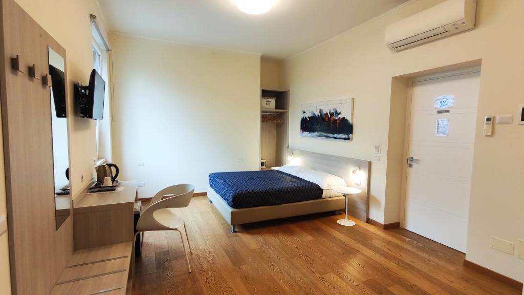 1 dormitorio con cama, escritorio y puerta en B&B Via delle 5 Terre, en La Spezia