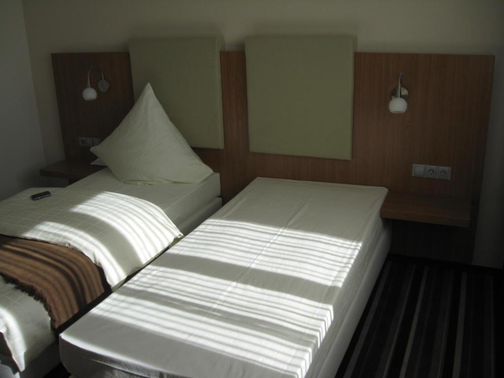 two beds sitting next to each other in a room at Qualitel Hilpoltstein in Hilpoltstein