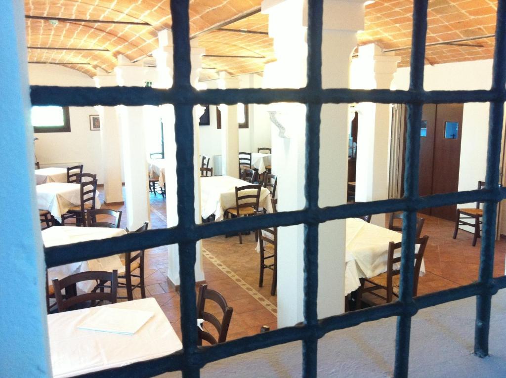 uma vista para um quarto com mesas e cadeiras através de uma janela em Antico Noce em Granarolo dellʼEmilia
