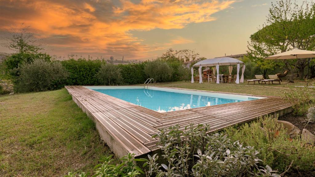 una piscina en un patio con cenador en Mulino dei Camini en Monteciccardo