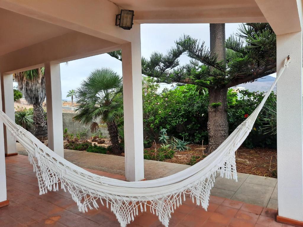 a hammock on a porch with a view of the ocean at Quintinha das Lombas in Porto Santo