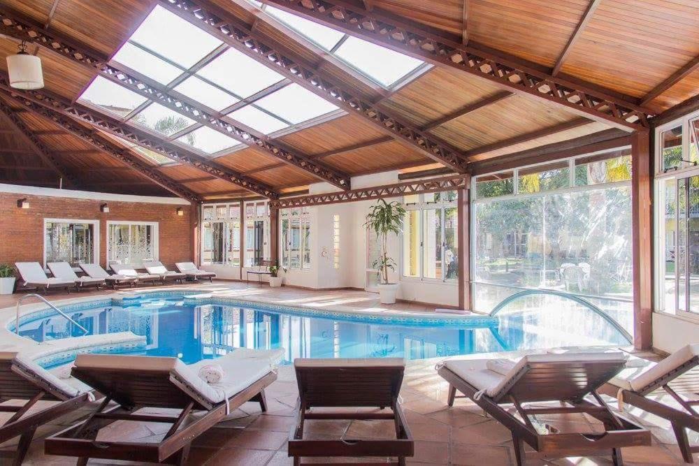 an indoor swimming pool with a conservatory with a glass ceiling at Costa Del Sol in Federación