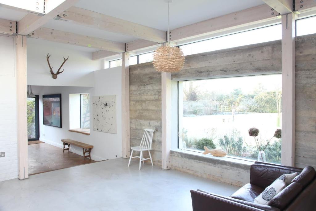 ein Wohnzimmer mit einem großen Fenster und einem Tisch in der Unterkunft Sky Room, Rendham (Air Manage Suffolk) in Saxmundham