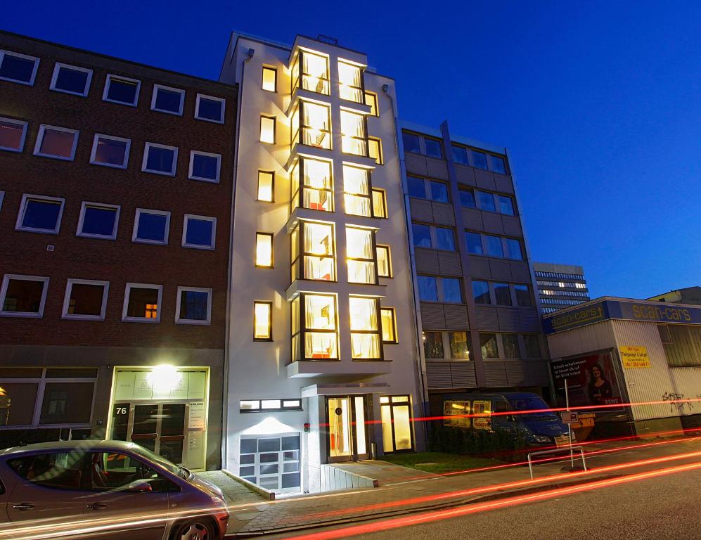 a building with lights on in a city at night at INA Boutique 072 Hamburg St Georg in Hamburg