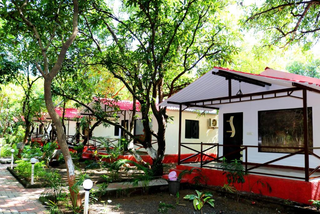 a small house with a red and white at The Wilds Villa Gir Jungle Stay with Swimming Pool in Sasan Gir