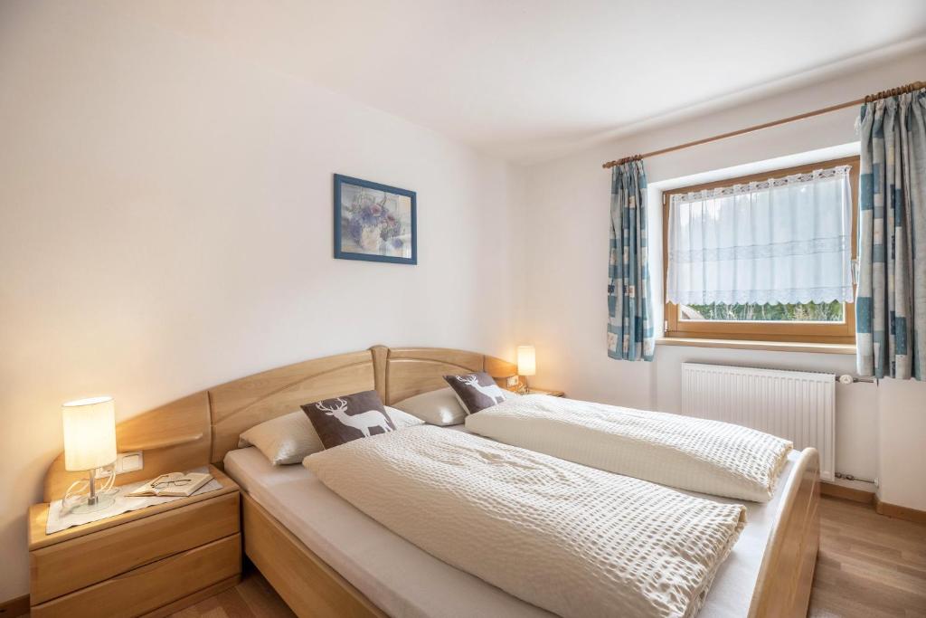 sypialnia z dwoma łóżkami i oknem w obiekcie Haus Belodei - Apt A w mieście San Martino in Badia