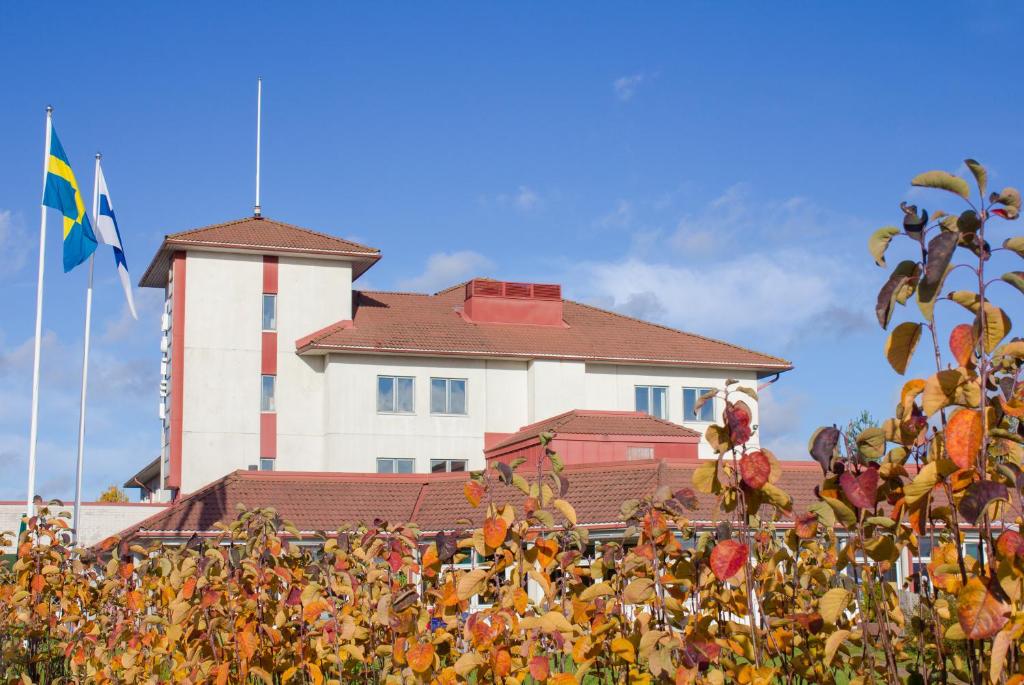 een gebouw met een vlag ervoor bij Hotel Kalkstrand in Pargas