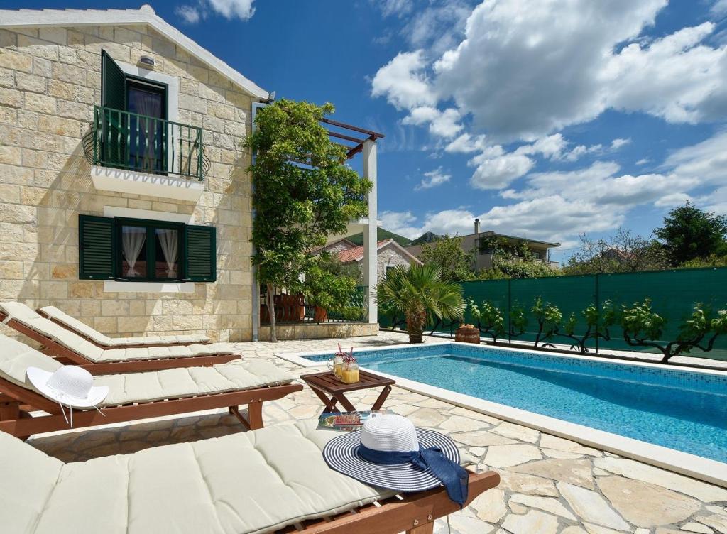 einen Hinterhof mit einem Pool und einem Haus in der Unterkunft Villa Josip near Omiš , private pool in Omiš