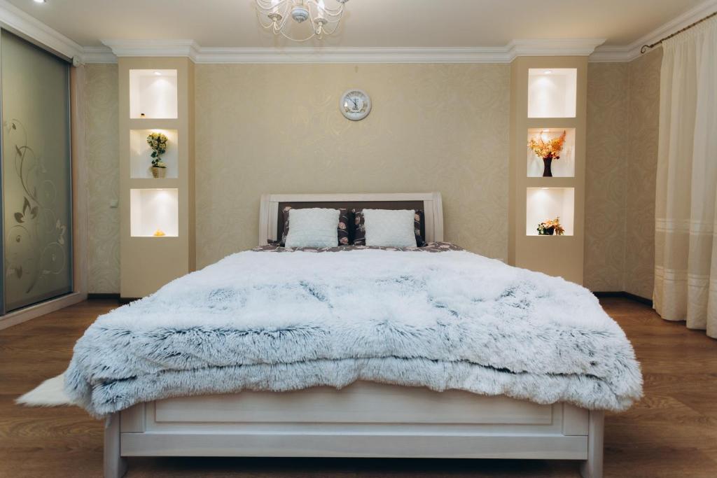 um quarto com uma cama grande e um cobertor branco em Luxury Apartment em Sumy