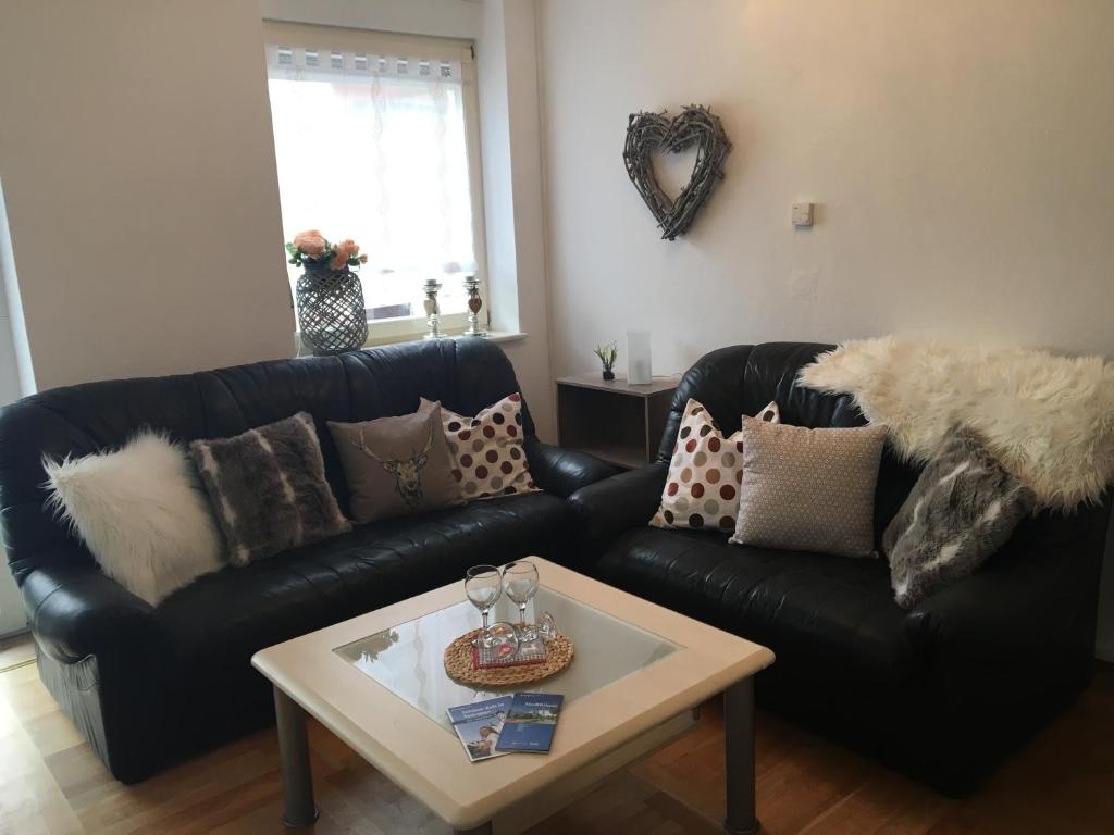 a living room with a black leather couch and a coffee table at Allgäutraum Ferienwohnung Nr 4 in Kempten