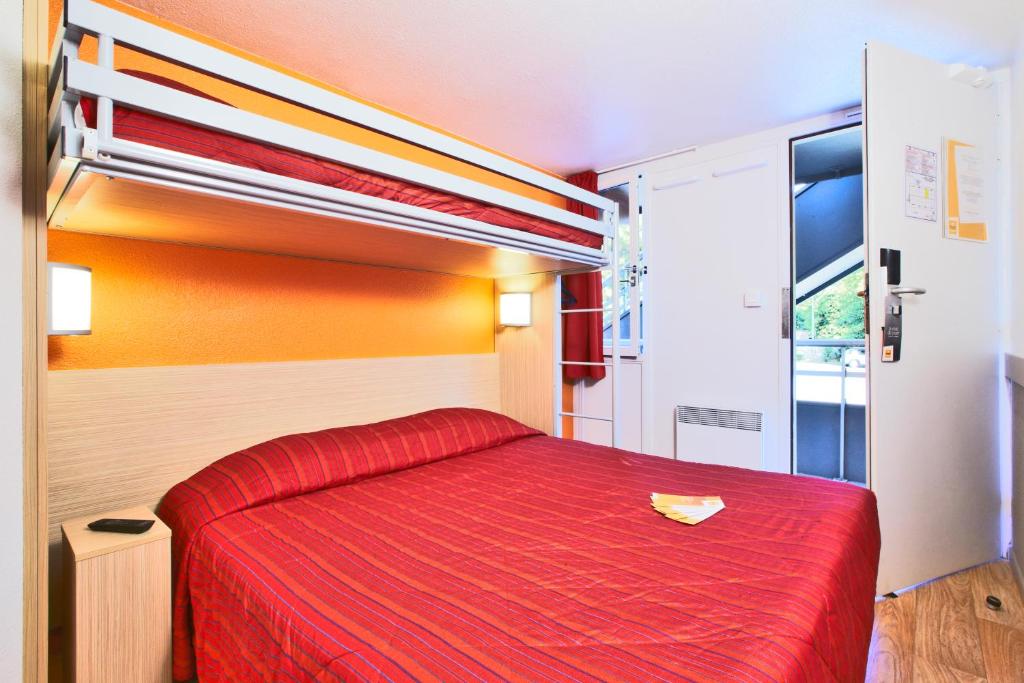 um quarto com uma cama vermelha e um cobertor vermelho em Premiere Classe Tours Nord em Parçay-Meslay
