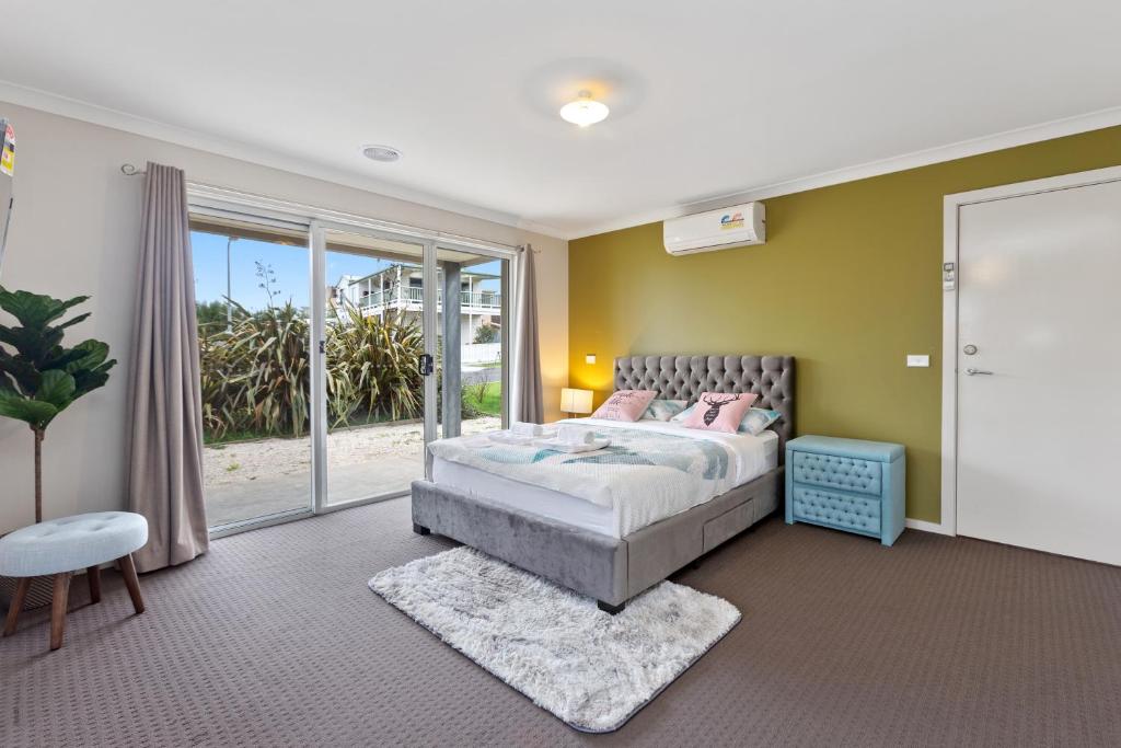 a bedroom with a bed and a large window at 32 Scenic Apollo in Apollo Bay