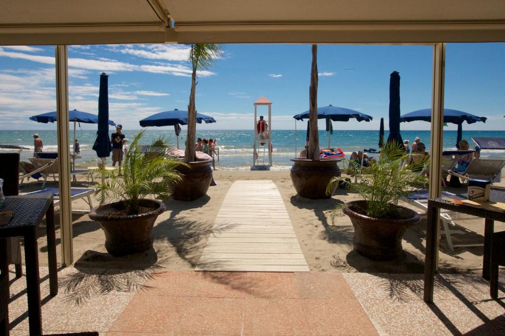 Blick auf einen Strand mit Sonnenschirmen und das Meer in der Unterkunft Grand Hotel Mediterranee in Alassio