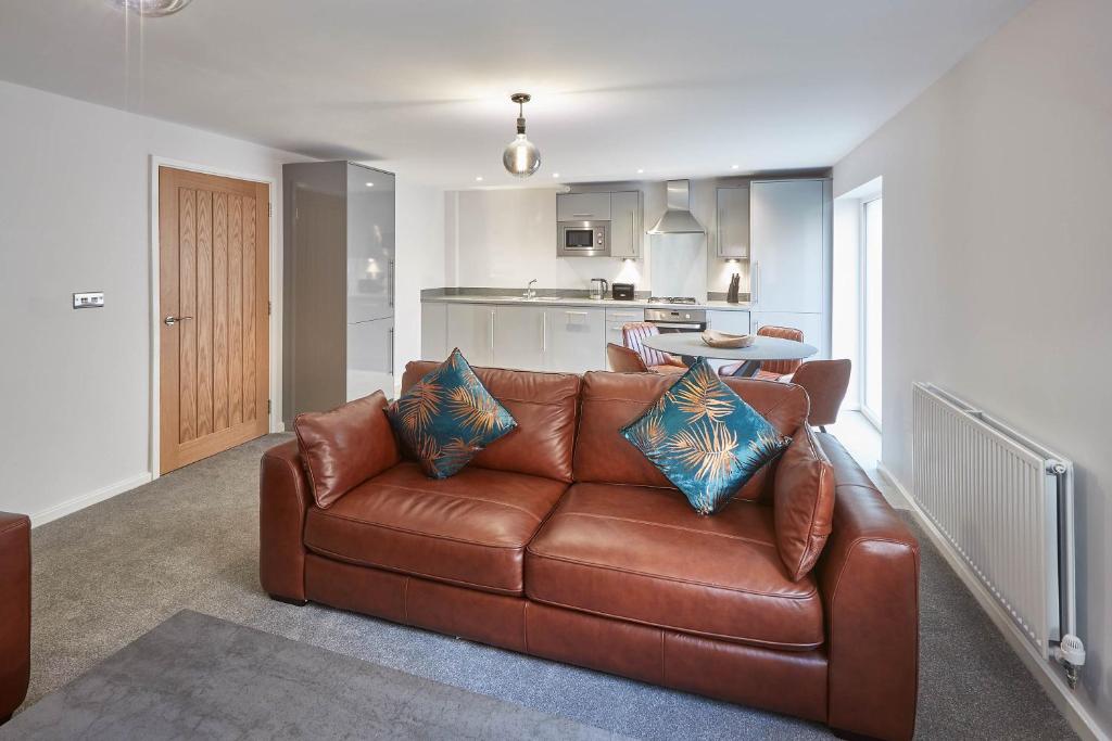 uma sala de estar com um sofá de couro castanho e uma cozinha em Host & Stay - Bagdale Rise em Whitby