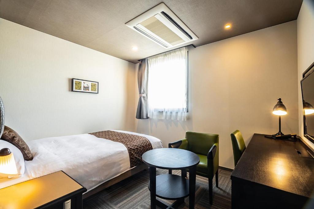 Tempat tidur dalam kamar di Hotel Quest Shimizu