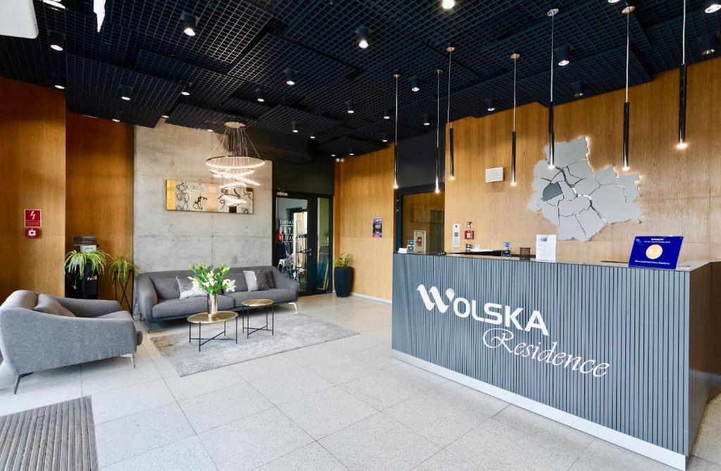 a lobby with a wushia furniture sign on the wall at Wolska Residence in Warsaw