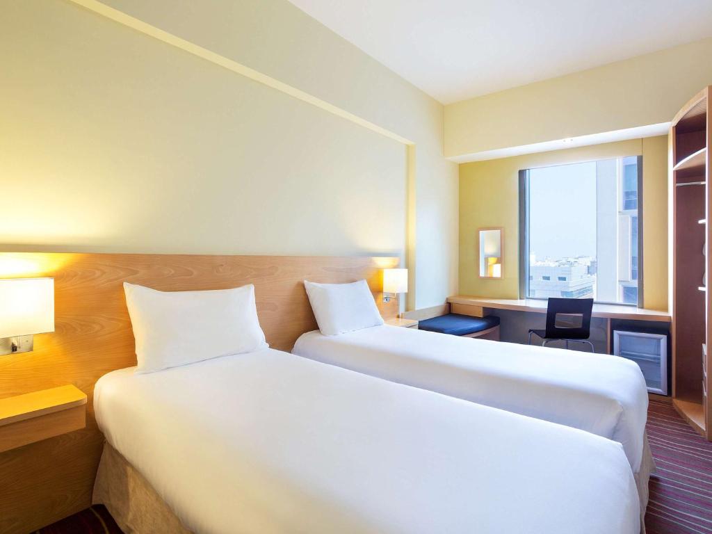 Postel nebo postele na pokoji v ubytování ibis Dubai Al Rigga