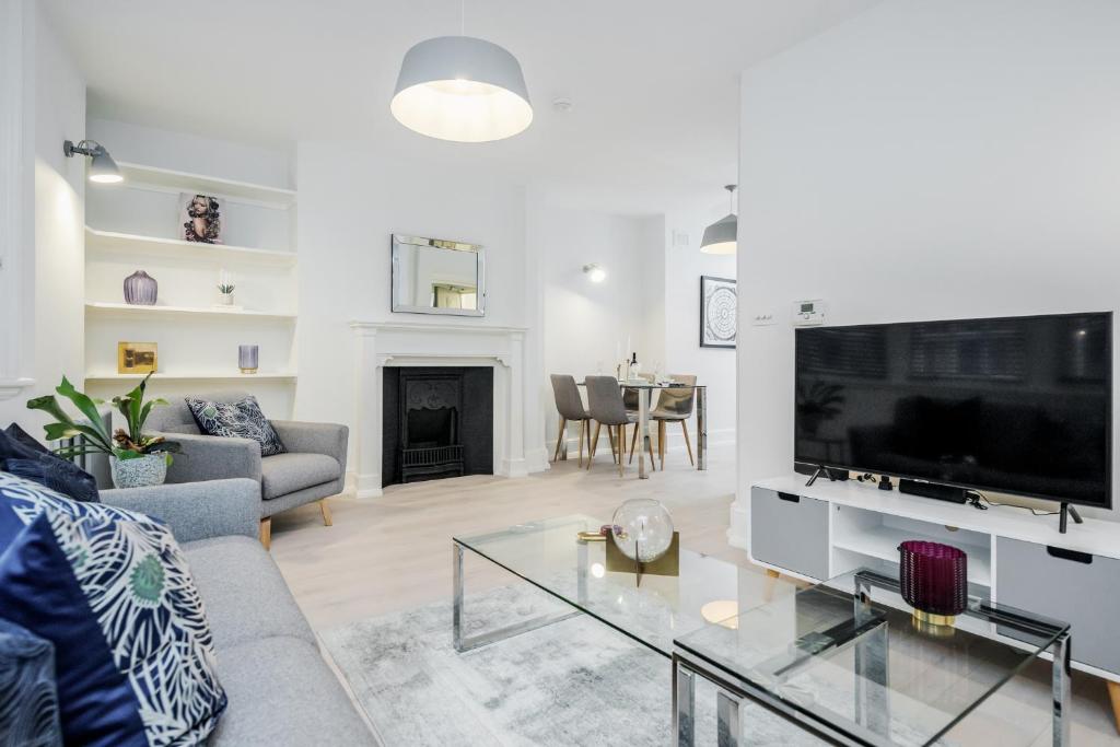 a living room with a couch and a tv at Stay Kula London - Covent Garden St Martin's Lane in London