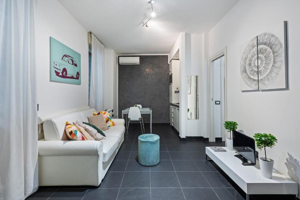 een woonkamer met een witte bank en een tafel bij Easylife - The Magnificent Flat Porta Venezia in Milaan