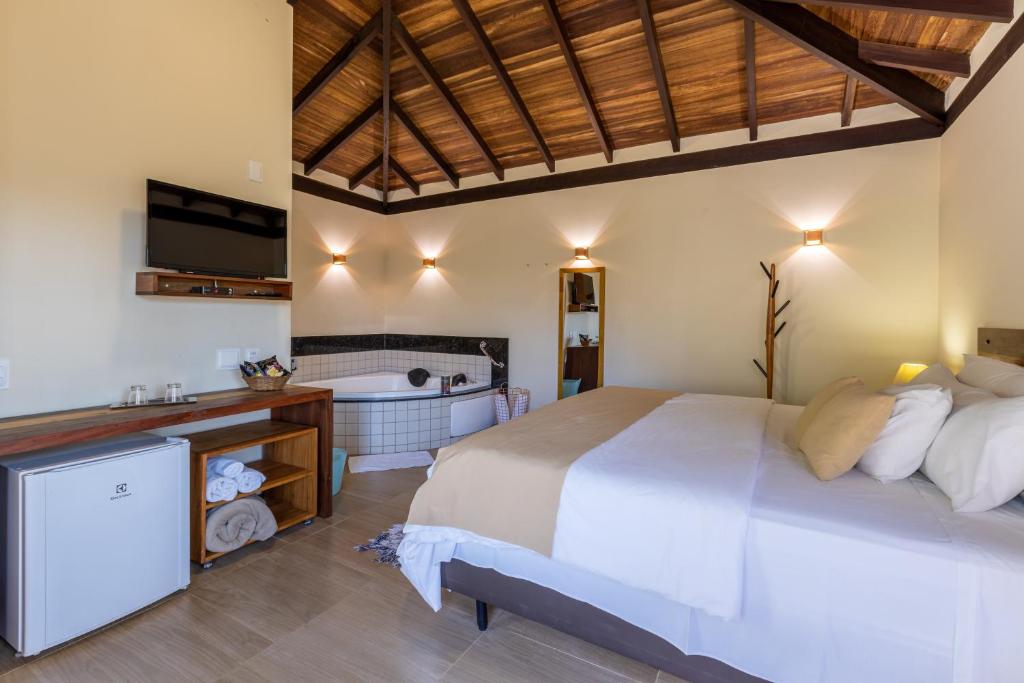 a bedroom with a large bed and a bath room at Villa Severina in Brumadinho