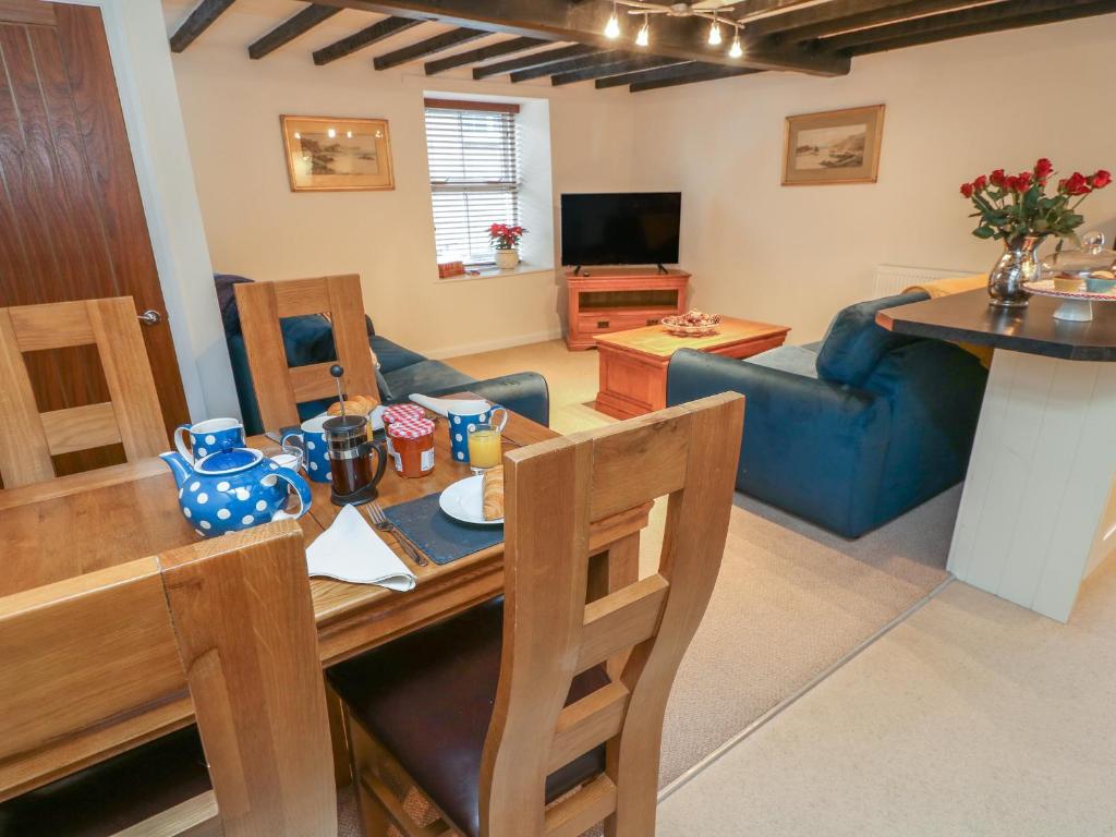 a living room with a table and a blue couch at 3 Eden Lodge in Kirkby Stephen