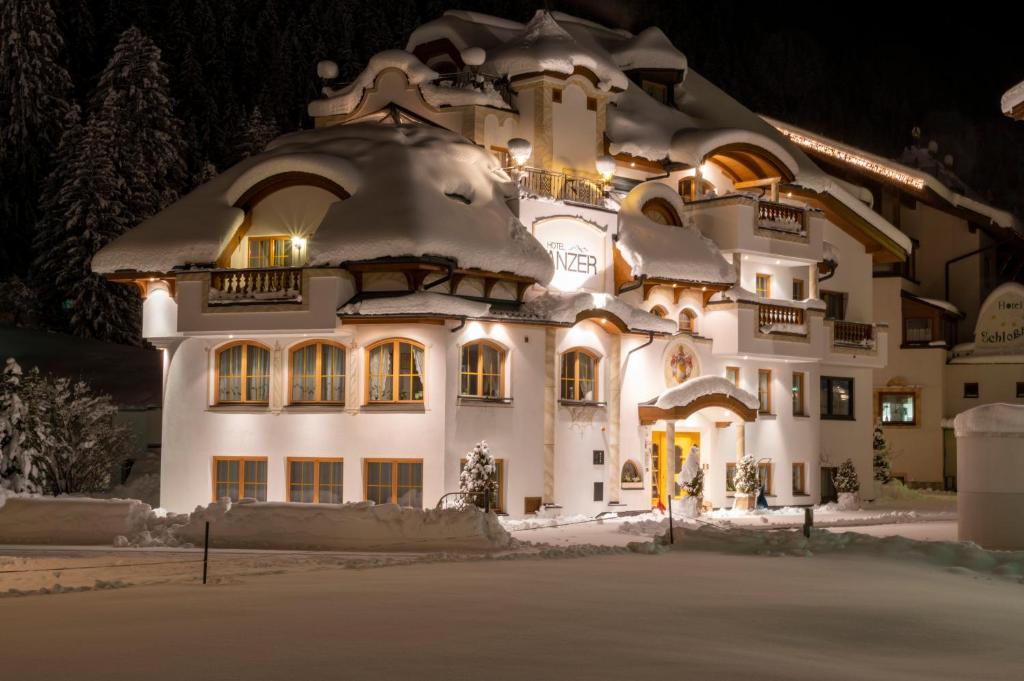 een groot wit gebouw met een met sneeuw bedekt dak bij Hotel Tanzer in Ischgl