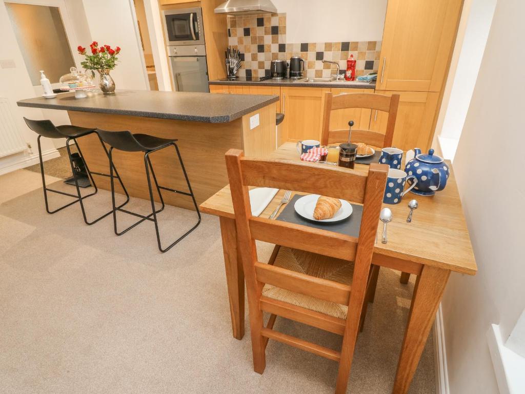 - une cuisine avec une table, des chaises et un comptoir dans l'établissement 2 Eden Lodge, à Kirkby Stephen