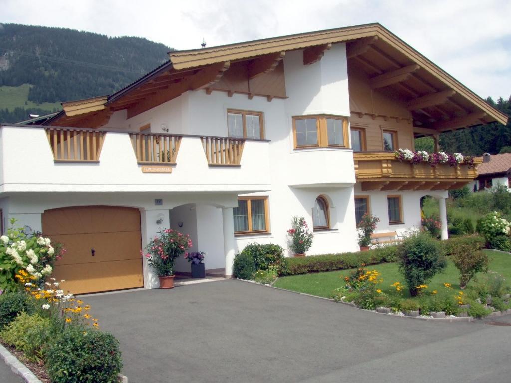 ein großes weißes Haus mit Garage in der Unterkunft Ferienwohnungen Niederacher in Fieberbrunn