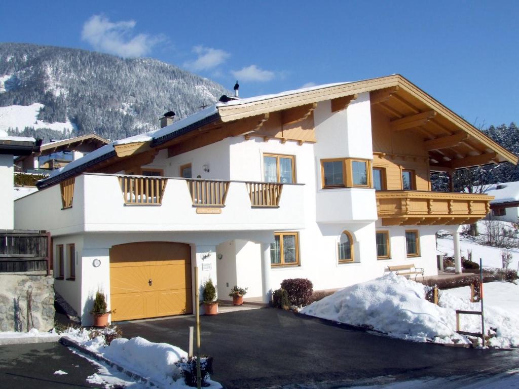 a house in the snow with a garage at Ferienwohnungen Niederacher in Fieberbrunn