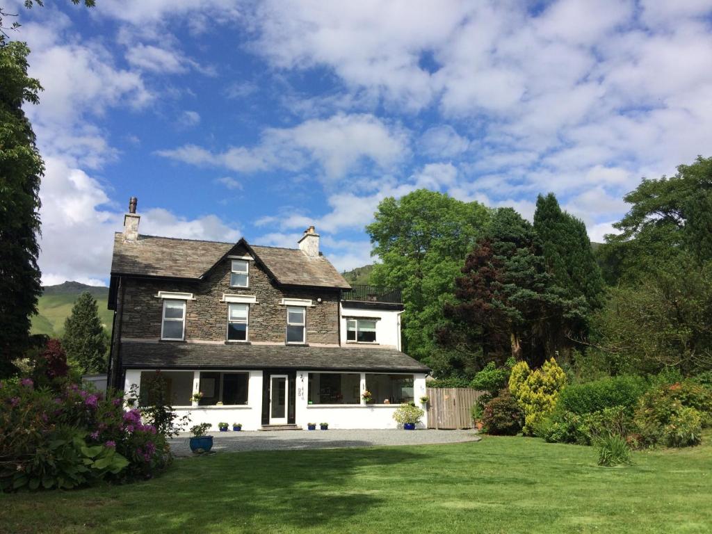 a large black and white house with a yard at Lake View Country House in Grasmere