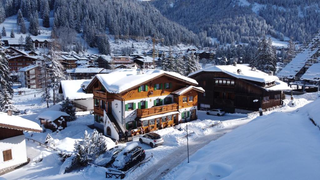 a ski lodge in the snow in a village at Majon del Tisler in Canazei