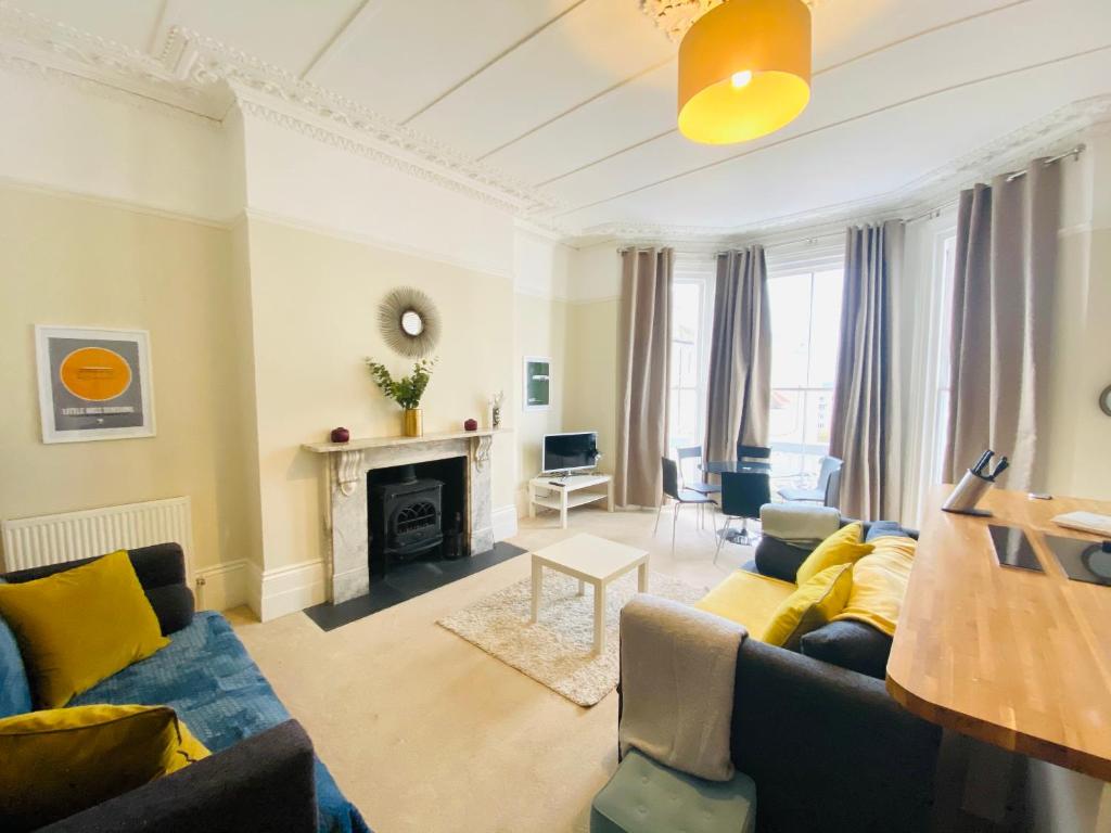 a living room with a couch and a fireplace at Elegant Spacious Apartment in Heart of St Leonards in Hastings