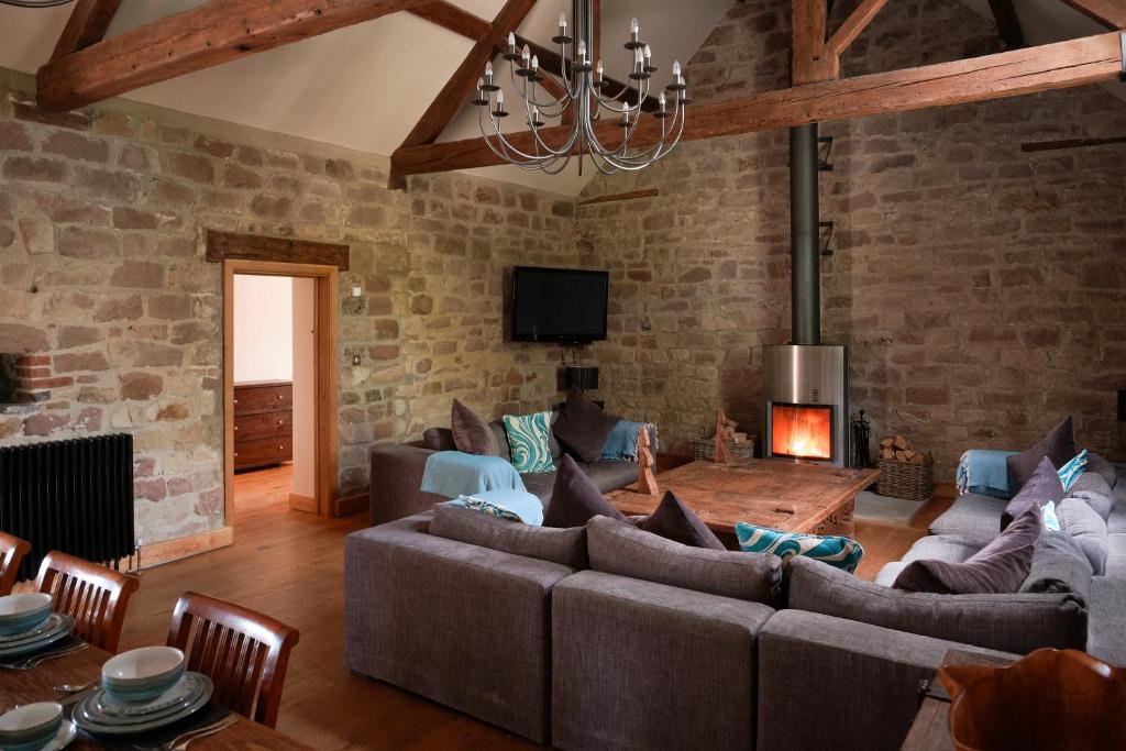 a living room with a couch and a fireplace at Woodpecker Loft at Millfields Farm Cottages in Ashbourne