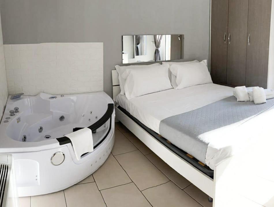 sypialnia z łóżkiem i wanną obok łóżka w obiekcie De Gasperi House w mieście Napoli
